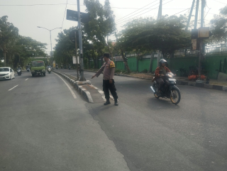Bhabinkamtibmas Polsek Kenjeran Pantau Arus Lalu Lintas di Pertigaan Jalan Nambangan