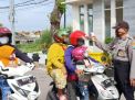Anggota Piket Pospam Suramadu Polres Tanjung Perak Cek Suhu Badan Pengendara Ke Madura