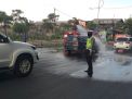Unit Lantas Polsek Asemrowo Bantu Petugas Damkar Lakukan Penyemprotan Disinfektan di Pintu Tol