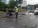 Anggota Satlantas Polres Tanjung Perak Dibantu Masyarakat, Lakukan Pengurukan Jalan Berlobang