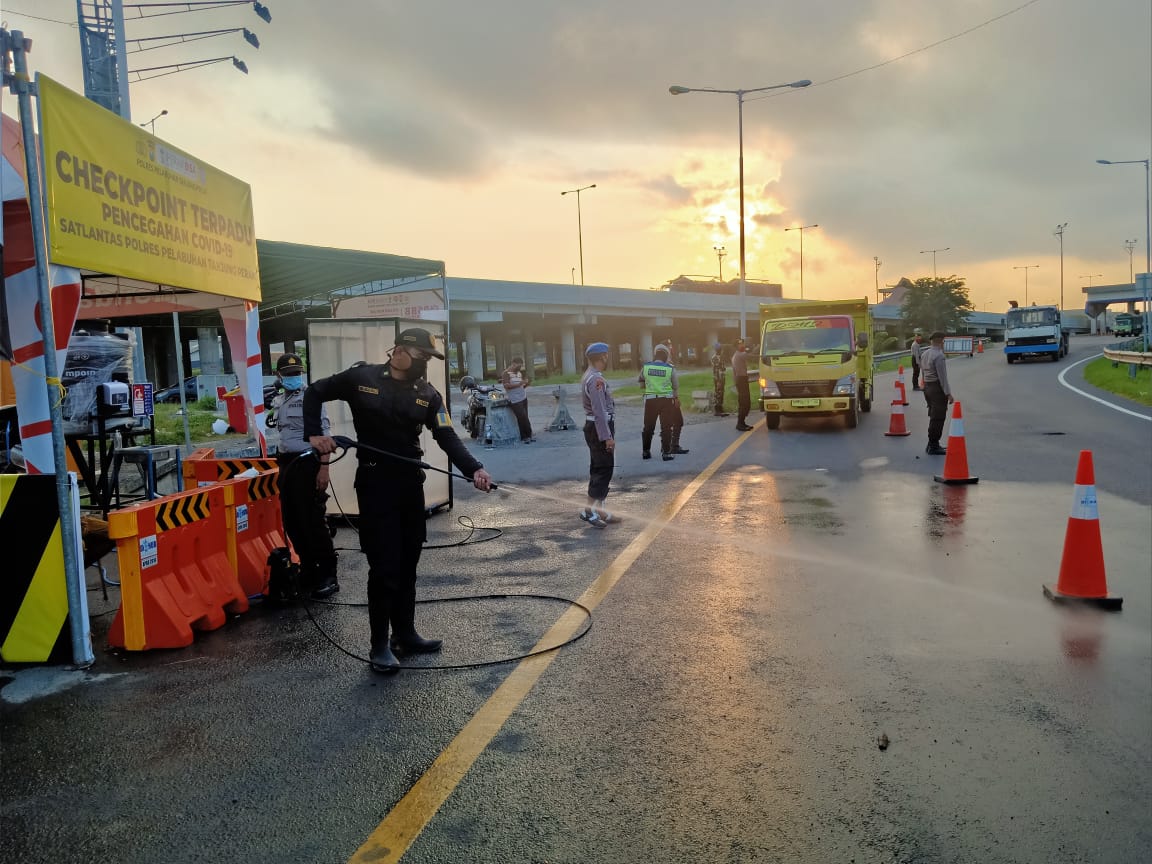Personil Pospam Polres Tanjung Perak Lakukan Penyemprotan Disinfektan Terhadap Setiap Kendaraan Masuk