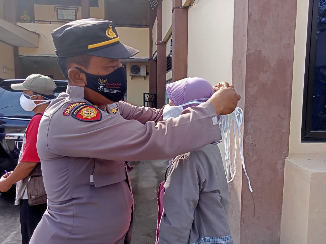 Personil Polsek Kenjeran Bagikan Masker Kepada Pengguna Jalan di Depan Mapolsek