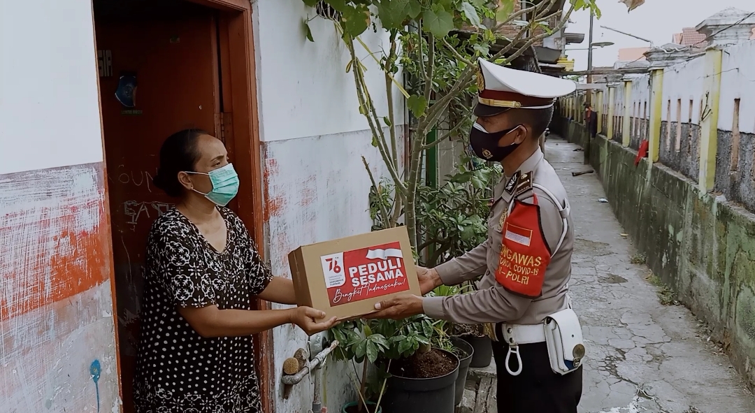 Polsek Asemrowo Bagikan Bantuan Sembako Untuk Warga Kurang Mampu di Jalan Asem Raya